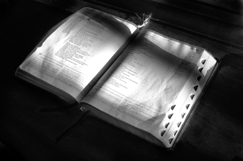 Open Bible with shadow of a cross on the pages